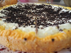 Een detailopname van een dessert met een romige witte topping en chocoladeschaafsel.