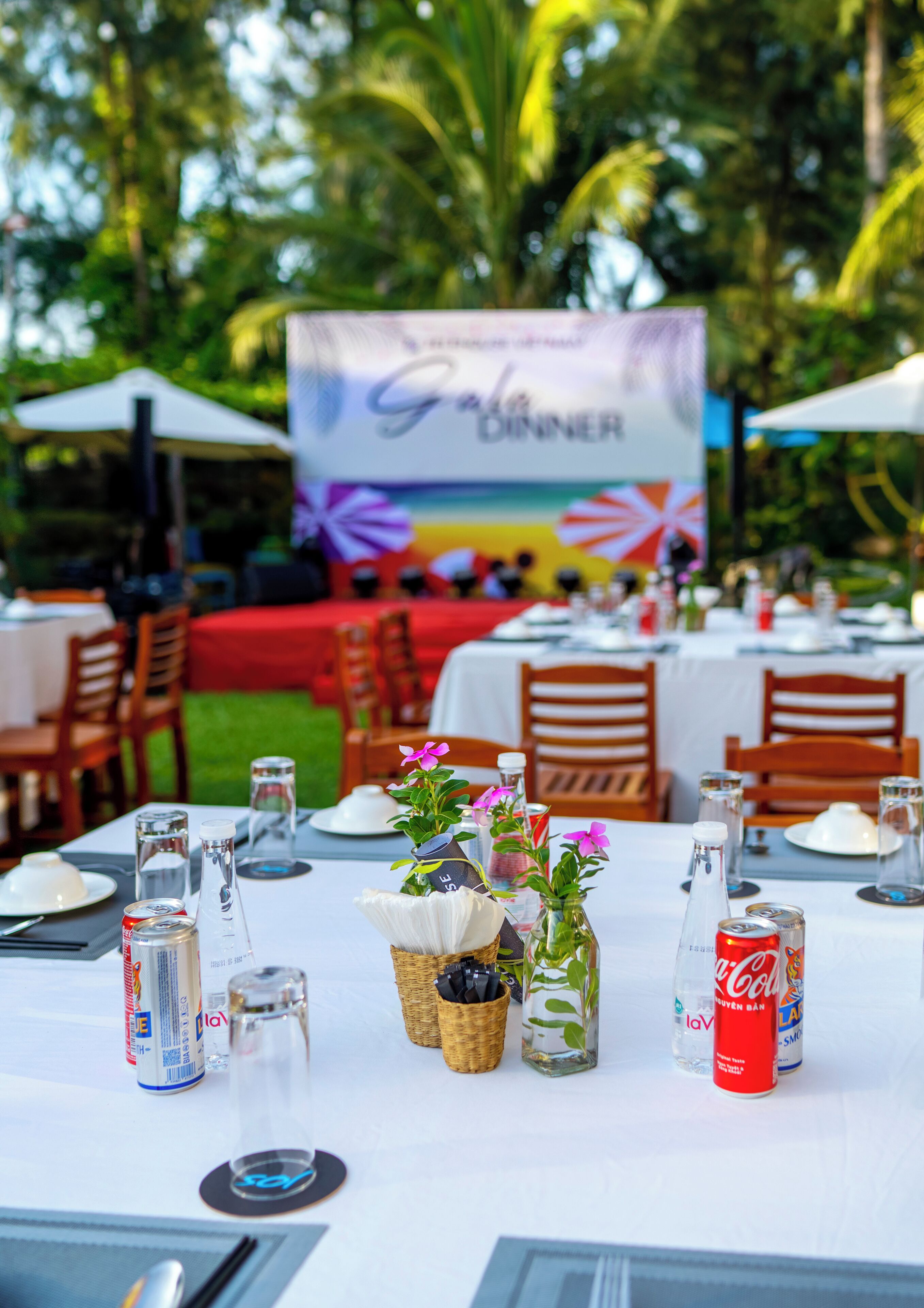 A dining table set for a meal with a banner in the background.