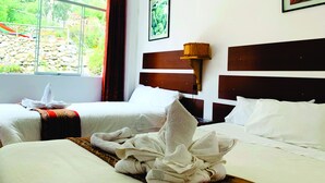 A hotel room with two beds, a large window with a view of greenery, a painting on the wall, and a wall-mounted lamp. - Inka Khawarina Tambo Lodge (Ollantaytambo)