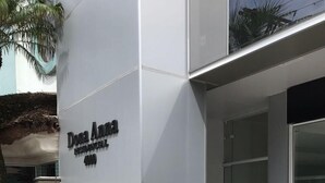 The exterior of Dona Anna Resort & Spa, featuring a modern design with a prominent entrance and a well-maintained garden area. - Apartamento Edifício Dona Anna (Balneário Camboriú)