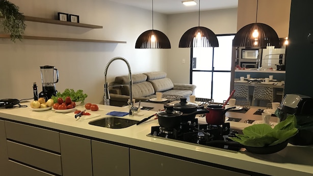 A modern kitchen with a central island, built-in appliances, and pendant lighting. - Apartamento Edifício Dona Anna (Balneário Camboriú)