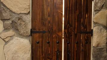A wooden door with metal hinges and a stone wall background.
