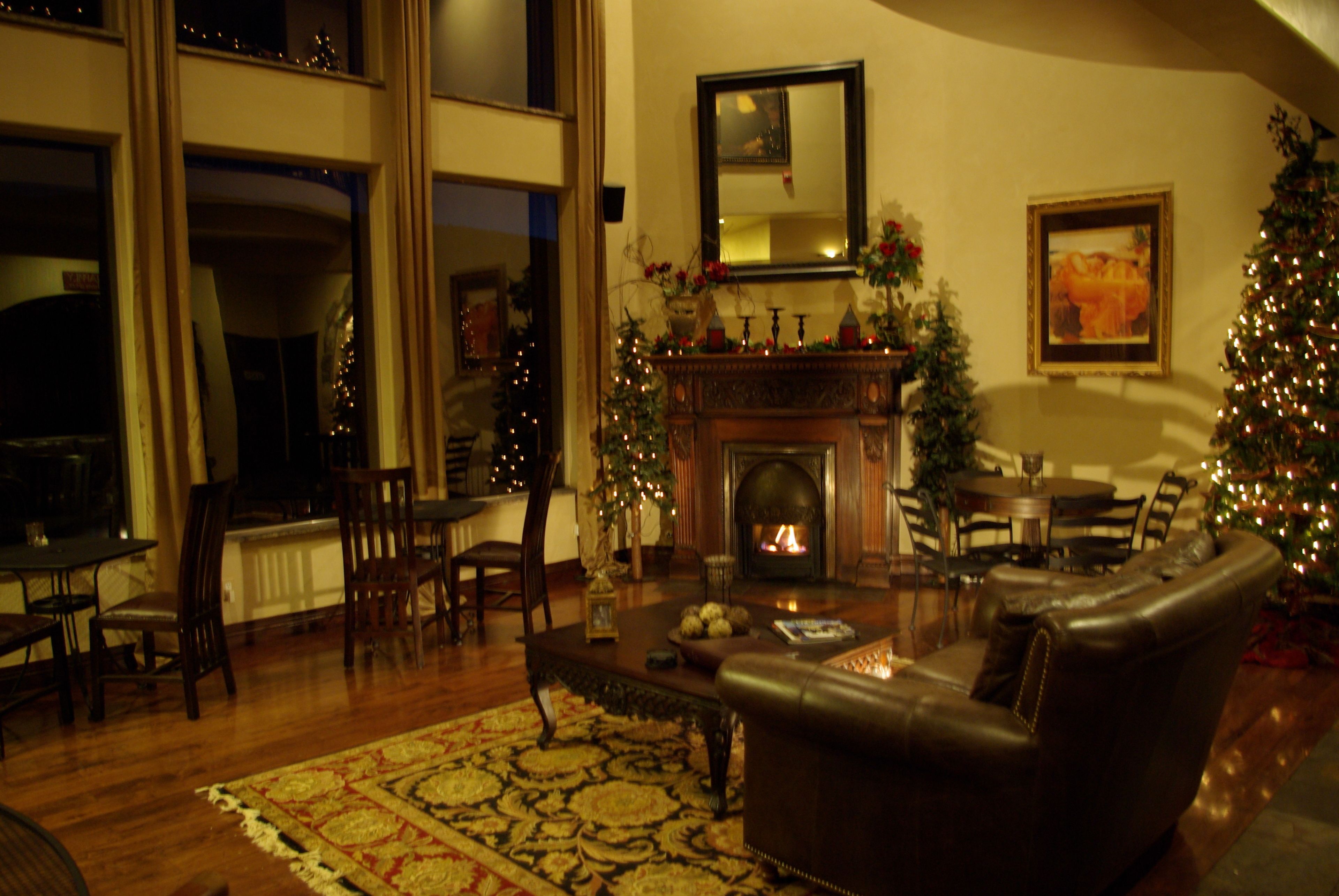 Una sala de estar acogedora con chimenea, sofá de cuero y adornos navideños.
