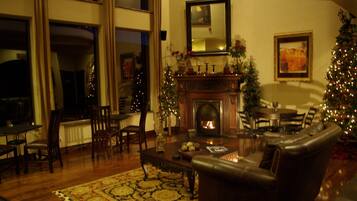 Una sala de estar acogedora con chimenea, sofá de cuero y adornos navideños.