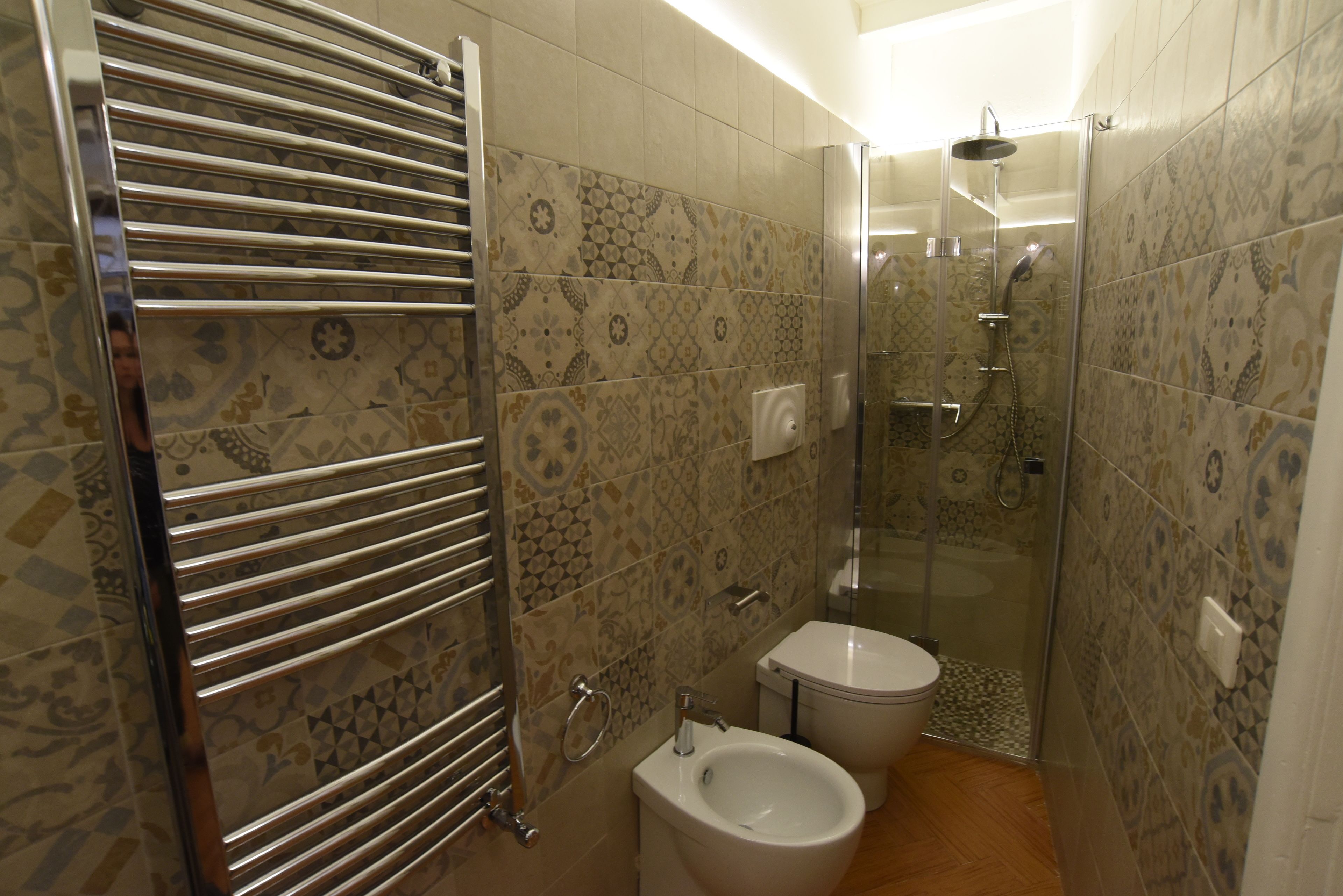 A bathroom with a shower, toilet, and bidet.