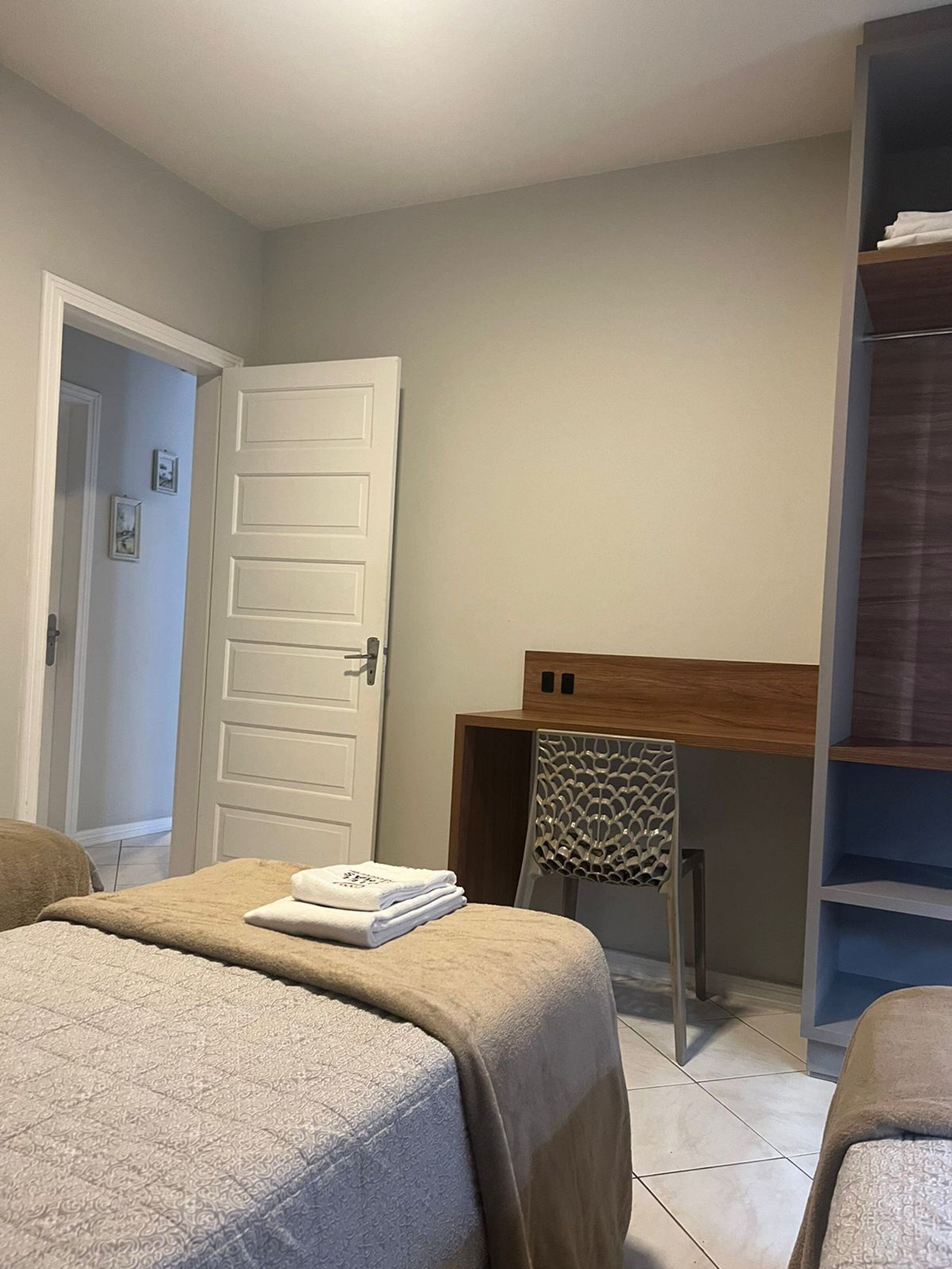 Une chambre à coucher avec un lit, un bureau et une chaise.