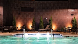 A swimming pool with a brick wall and lounge chairs in the background. - Residence Inn by Marriott Charlotte Northlake (Charlotte)