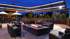 An outdoor patio with a fire feature, seating, and a pergola. - Residence Inn by Marriott Charlotte Northlake (Charlotte)