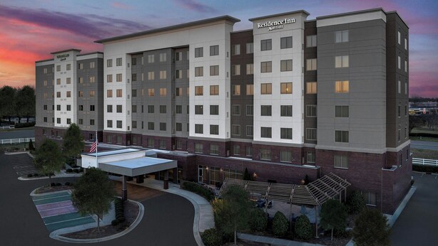 A multi-story hotel with a modern design, featuring a mix of brick and white facades, and a covered entrance area. - Residence Inn by Marriott Charlotte Northlake (Charlotte)