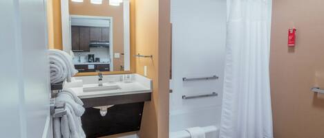 A modern bathroom with a sink, mirror, and shower curtain.