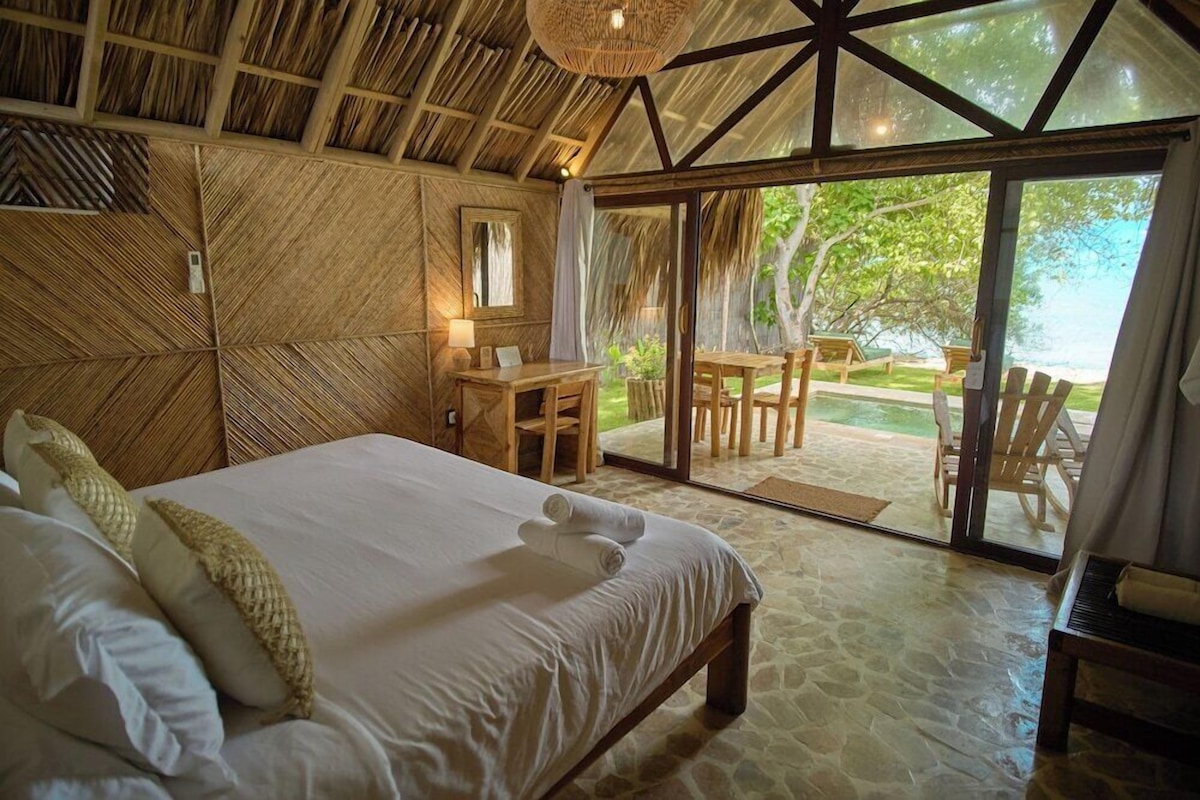A room with a bed, a desk, and a view of the outdoors.
