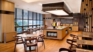 A modern restaurant with wooden furniture, large windows, and a central island with a beverage station. - Fairfield by Marriott Seoul (Seoul)