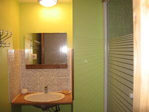 A bathroom with a sink, mirror, and tiled walls.