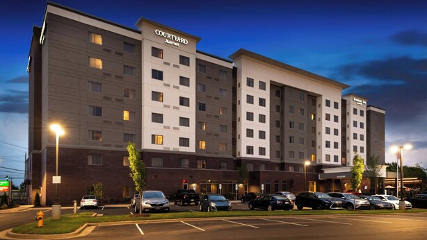 Un hôtel Courtyard Marriott doté d’un parking et de plusieurs voitures.