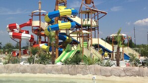 A water park with multiple water slides and a sandy beach area.