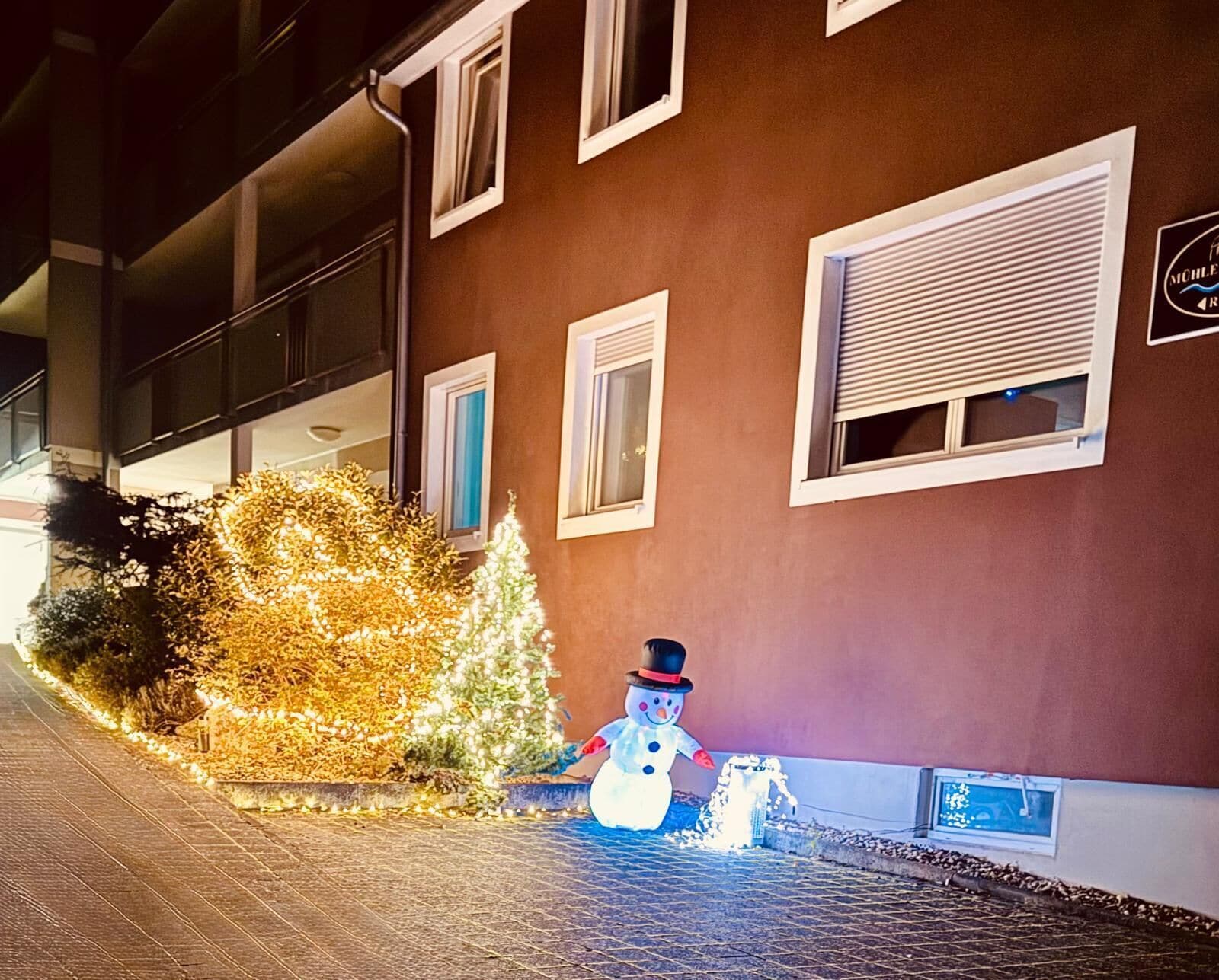 Un edificio con múltiples ventanas y una decoración de muñeco de nieve cerca de la entrada.