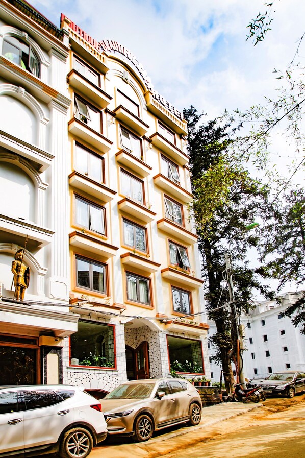 A multi-story hotel with a classic architectural style, featuring a prominent entrance with a decorative archway. - BEAUTIFUL SAPA HOTEL (Sa Pa)