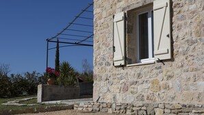 Un edificio de piedra con una ventana y un tendedero.