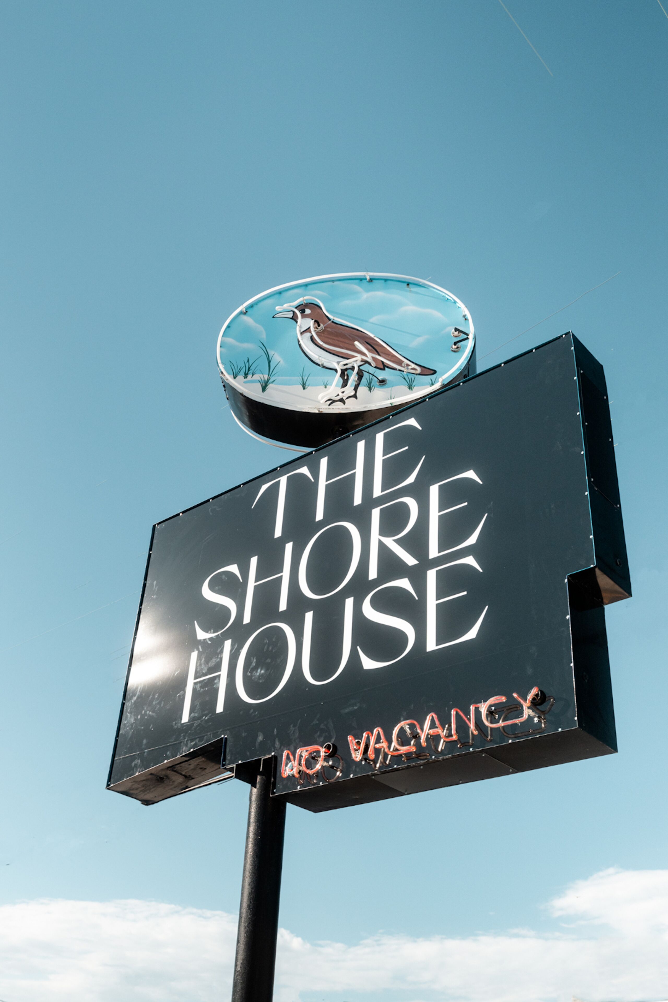 Segnaletica per "The Shore House" con un'illustrazione di un uccello e un cartello che indica "Nessuna disponibilità".
