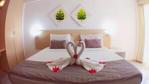 Een hotelkamer met een bed, kussens en een decoratie aan de muur.
