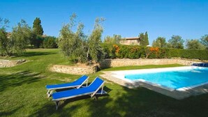A swimming pool with two blue lounge chairs, surrounded by a well-maintained lawn and trees. - Charming Tuscany Villa with magical Garden, shared pool,  Chianti Area  (Castelnuovo Berardenga)