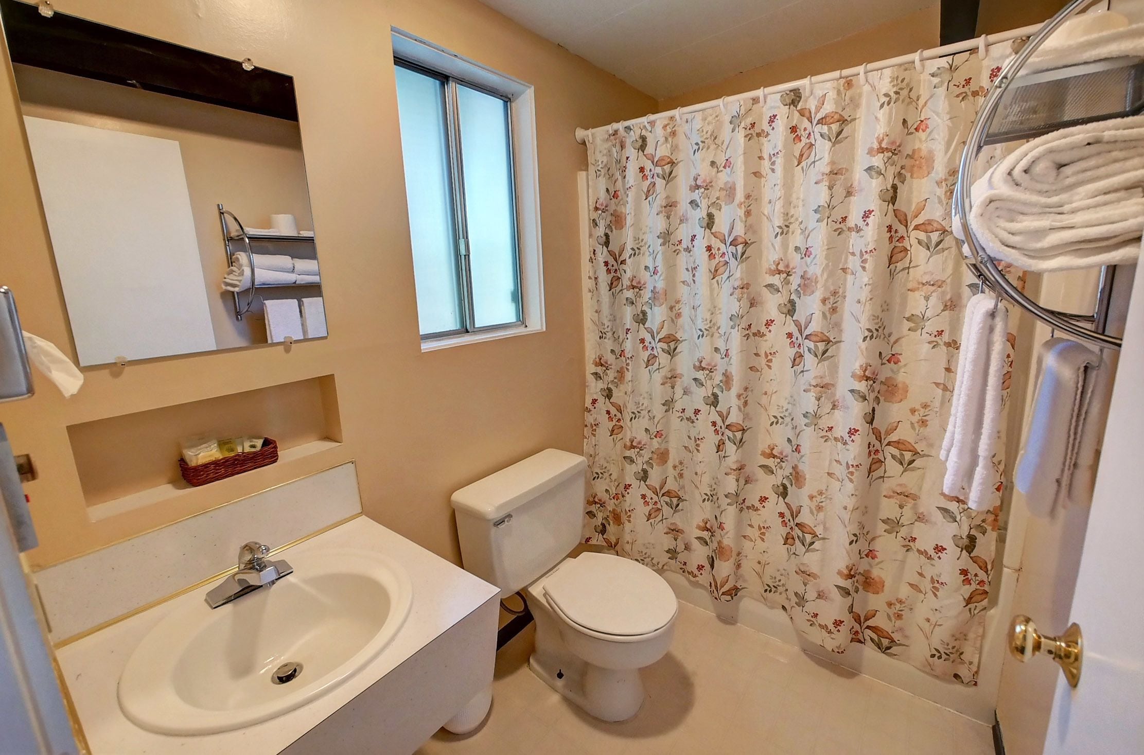 A bathroom with a sink, toilet, and shower curtain.