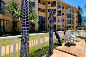 Un hotel con piscina, zona de estar al aire libre y un jardín cuidado.