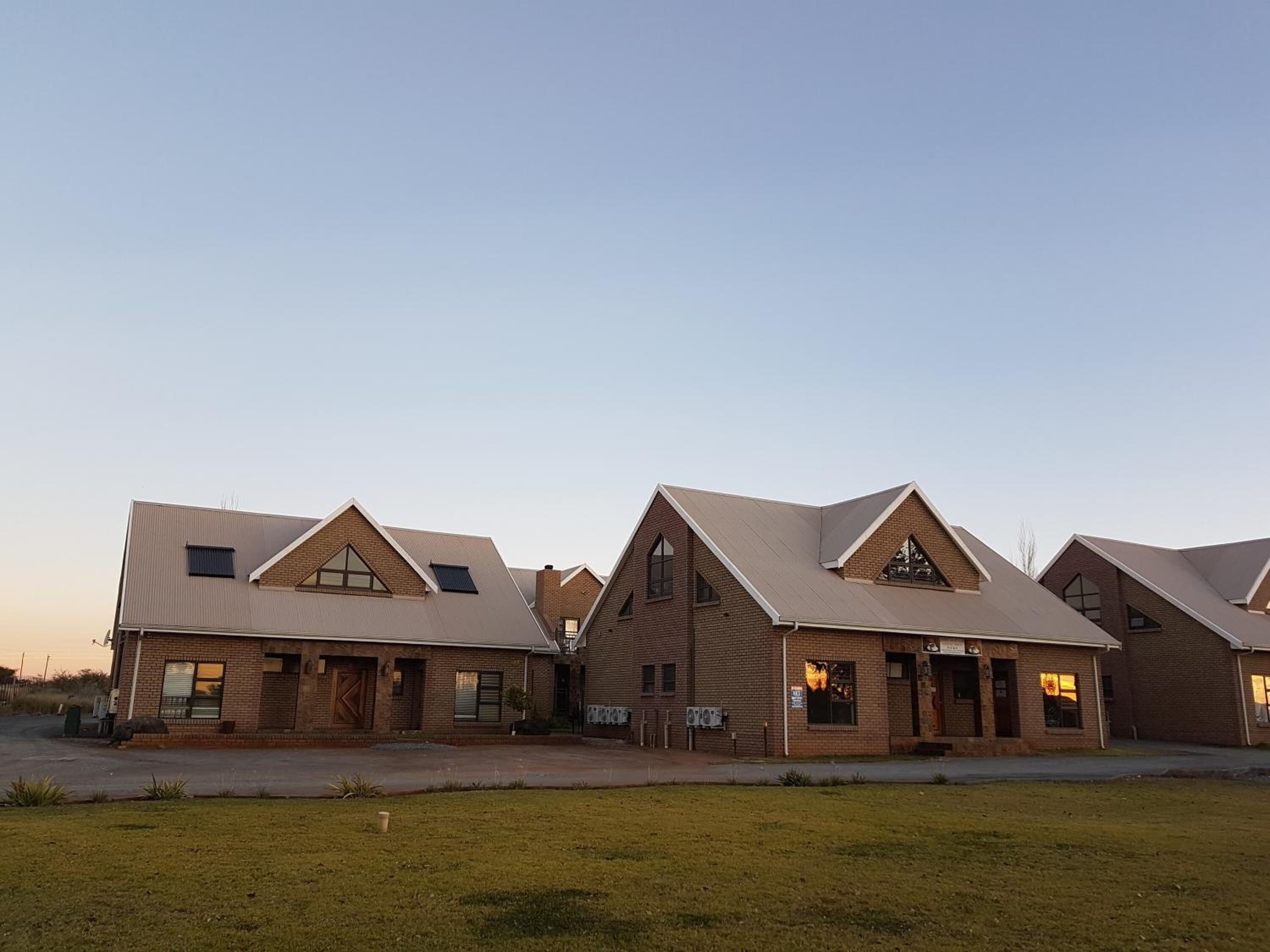 A row of modern buildings with pitched roofs and brick exteriors.
