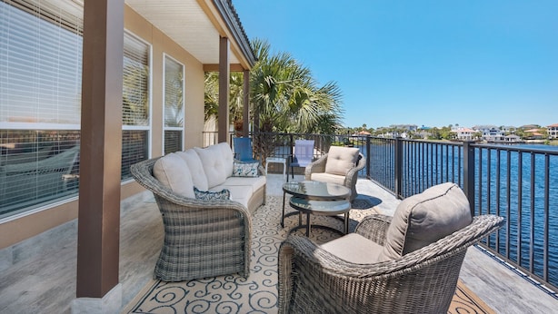 A balcony with wicker furniture, a glass table, and a view of the water. - Ocean view, walk to the beach, pool,  military/first responder discount 13A (Destin)