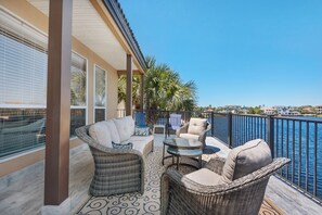 A balcony with wicker furniture, a glass table, and a view of the water. - Ocean view, walk to the beach, pool,  military/first responder discount 13A (Destin)