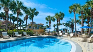 A swimming pool with lounge chairs and palm trees. - Ocean view, walk to the beach, pool,  military/first responder discount 13A (Destin)