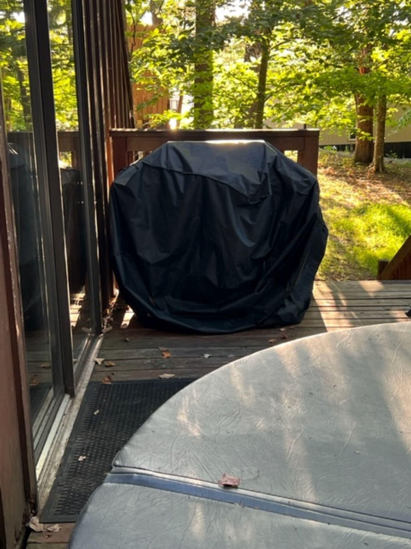 Un espacio de estar al aire libre cubierto con una mesa de metal y una terraza de madera.