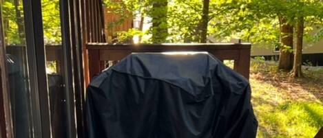 Un espacio de estar al aire libre cubierto con una mesa de metal y una terraza de madera.