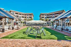 Stroll through the charming courtyard, surrounded by bicycles and brick walkways, with two-story buildings offering scenic views from their balconies.