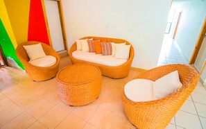 A room with wicker furniture including a sofa set and two ottomans. - Hotel On Vacation Magic Hill (San Andrés)