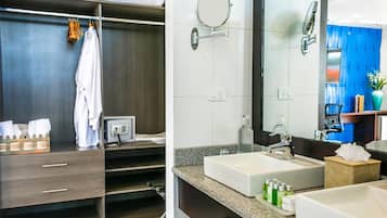 Un baño moderno con dos lavamanos, un tocador con espejo y un perchero para toallas.