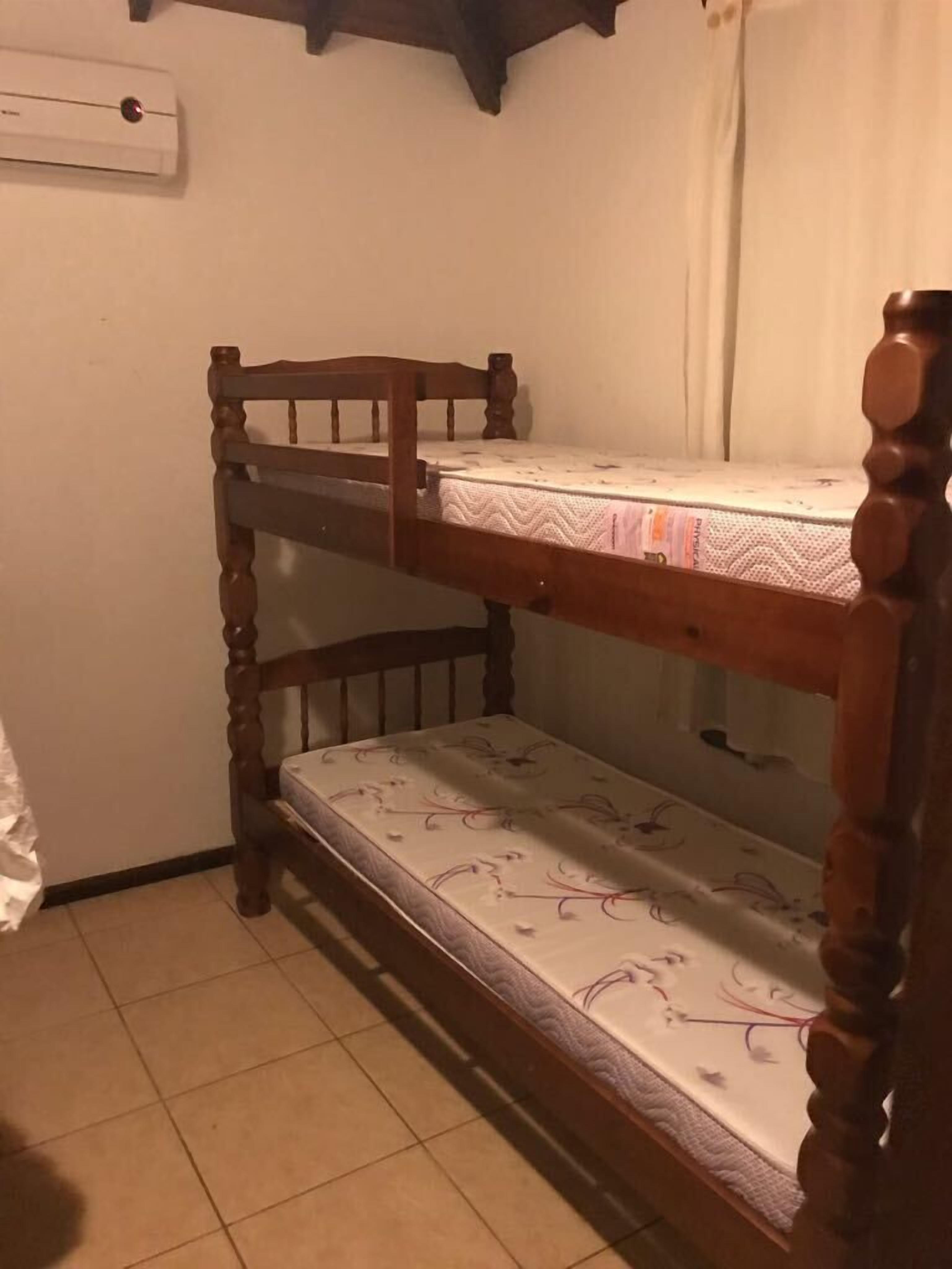A bunk bed with a wooden frame and a patterned mattress.