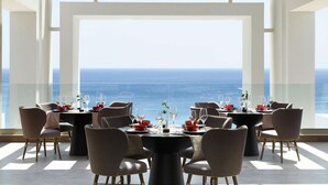 A dining area with tables set for two, overlooking a scenic ocean view. - Mayia Exclusive Resort & Spa - Adults Only - All Inclusive (Rhodes)