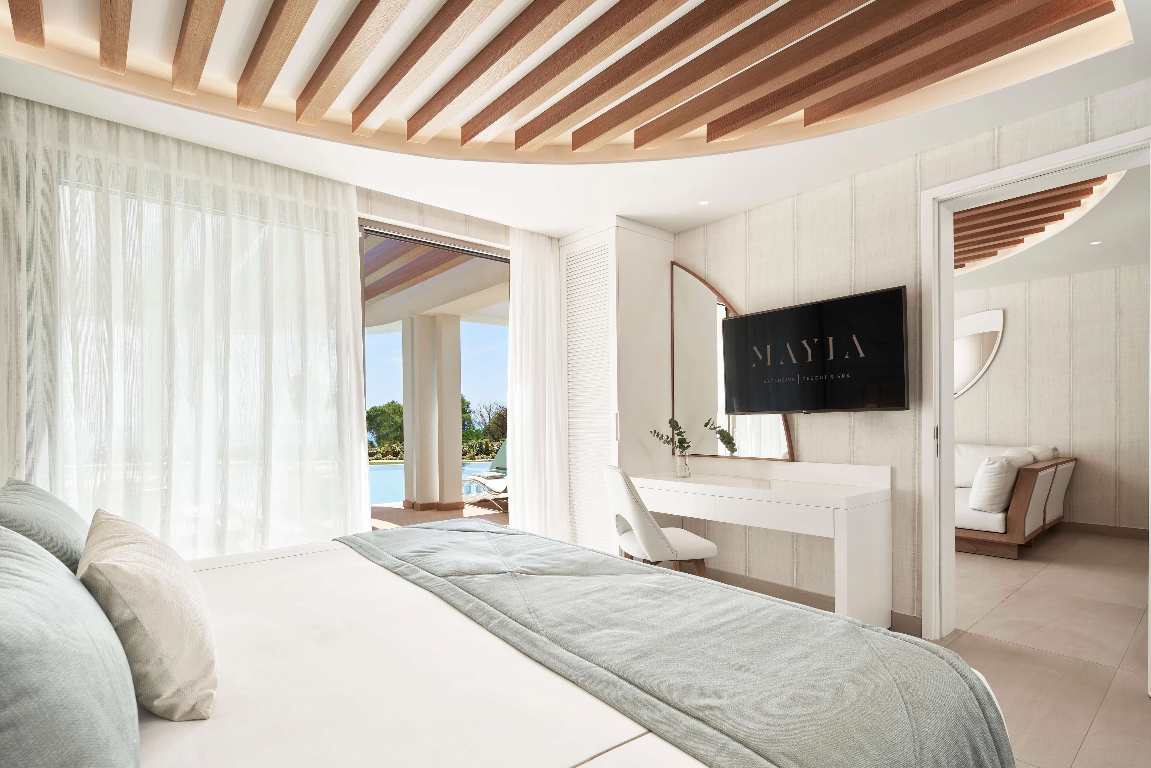 Un dormitorio moderno con una cama grande, un escritorio y un televisor.