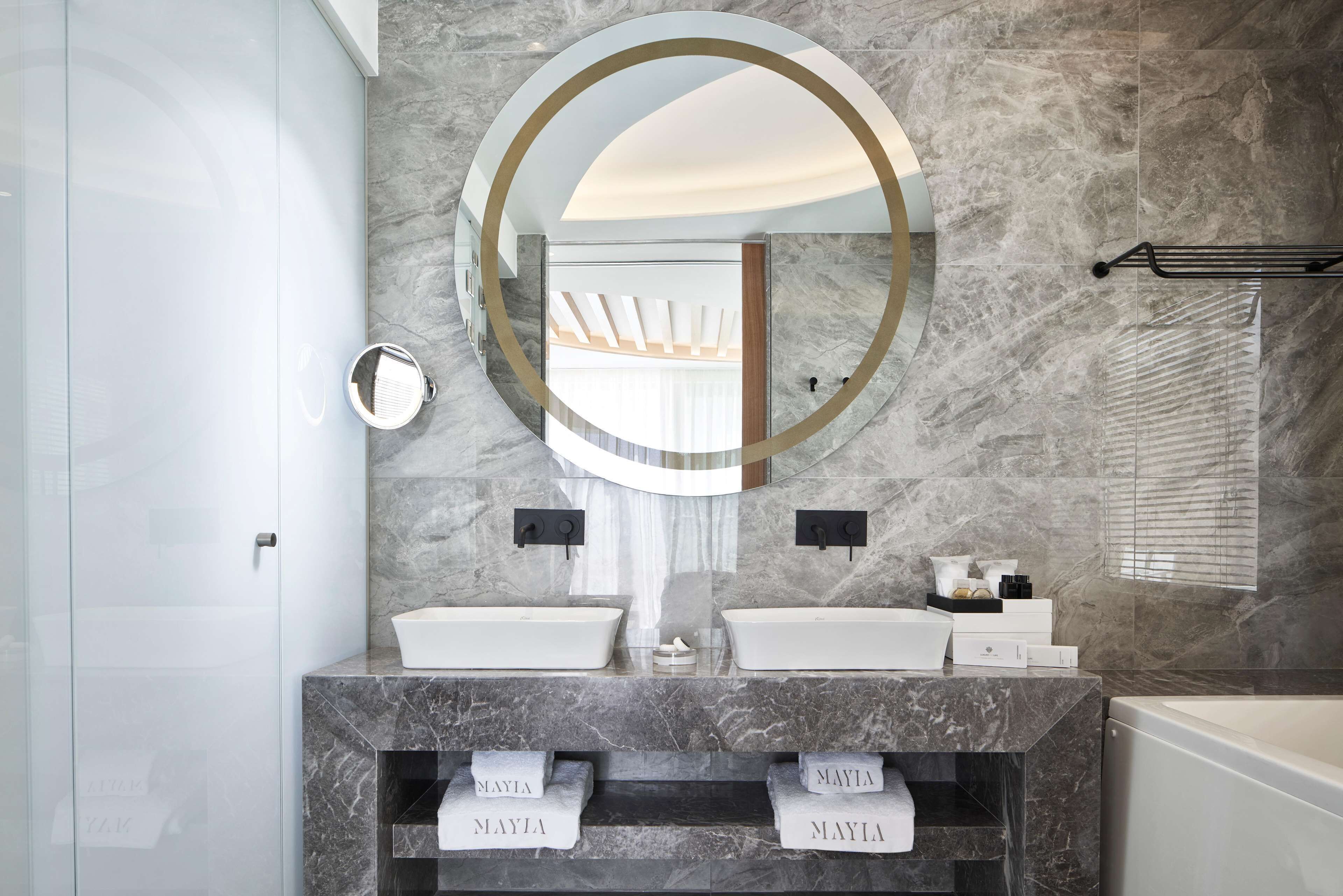 Un baño moderno con dos lavamanos, un espejo grande y una bañera.