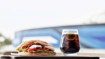 A sandwich and a glass of soda on a tray.