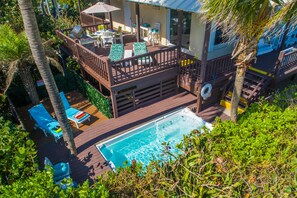 A pool area with a hot tub, lounge chairs, and a deck with a railing. - Xanadu:  ON.THE.BEACH! Heated pools, Ocean2River, Elevator, Dock,Spa: It's HUGE! (Stuart)