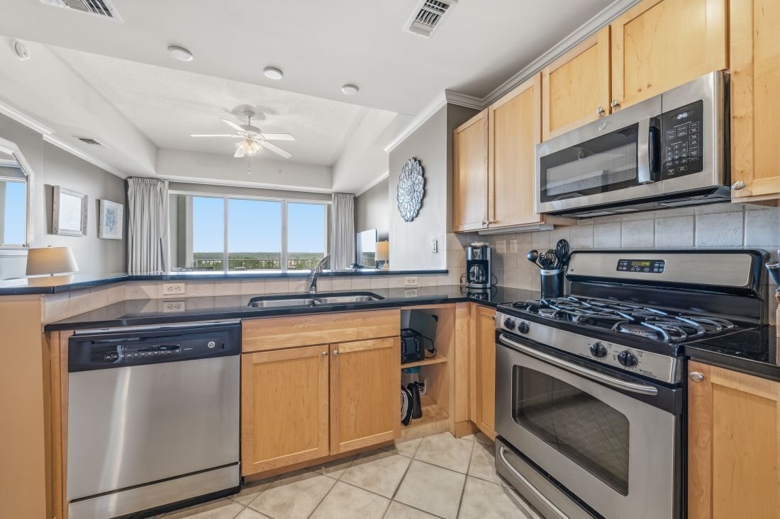 A kitchen with wooden cabinets, stainless steel appliances, a dishwasher, a stove, and a microwave.
