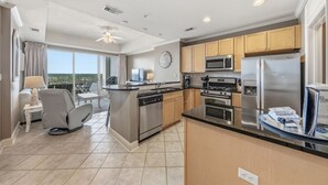 A modern kitchen with stainless steel appliances, a dining area with a view, and a balcony. - Waterfront Views | Boat-Friendly | Lazy River & Pools | On-site Dining (Orange Beach)