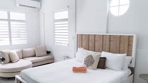 Un dormitorio moderno con una cama grande, un sofá y una pequeña mesa redonda.