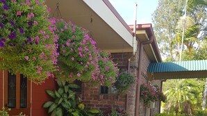Une maison en briques avec un porche couvert, des plantes en pot et un chemin de gravier.