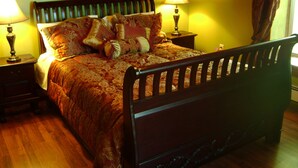 Une chambre à coucher avec un lit en bois, deux tables de chevet et des lampes.