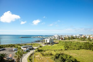 A coastal town with a marina, green fields, and modern buildings.