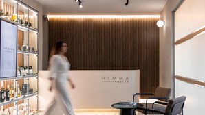 A modern interior with a wooden panel wall, a reception desk, and a seating area. - Hemma Bogotá Chapinero Premium Suites Hotel (Bogotá)