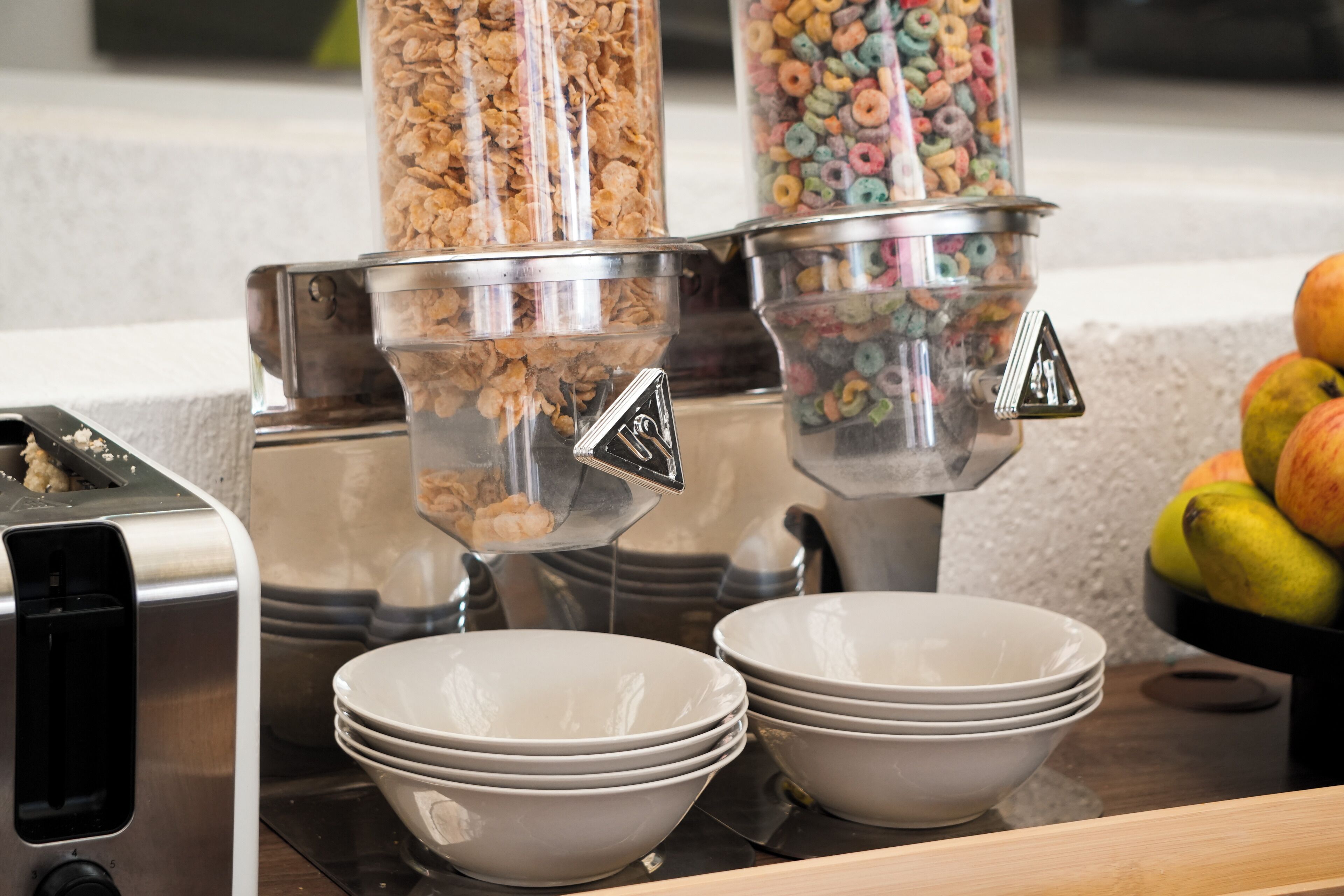 Una estación de desayuno con dispensadores y tazones para cereales.